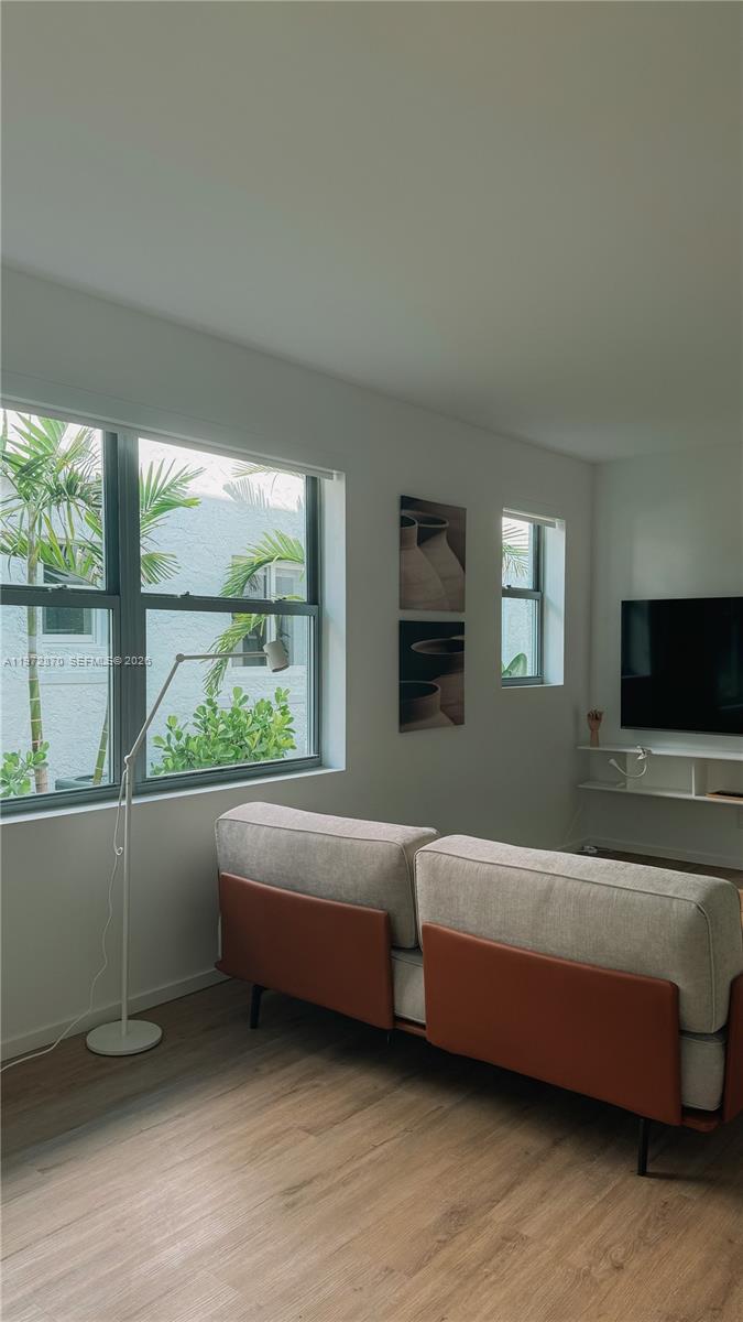 128 Northeast 46th Street, Unit 3 Miami, FL 33137 - Photo 10 of 17 a living room with furniture and a flat screen tv