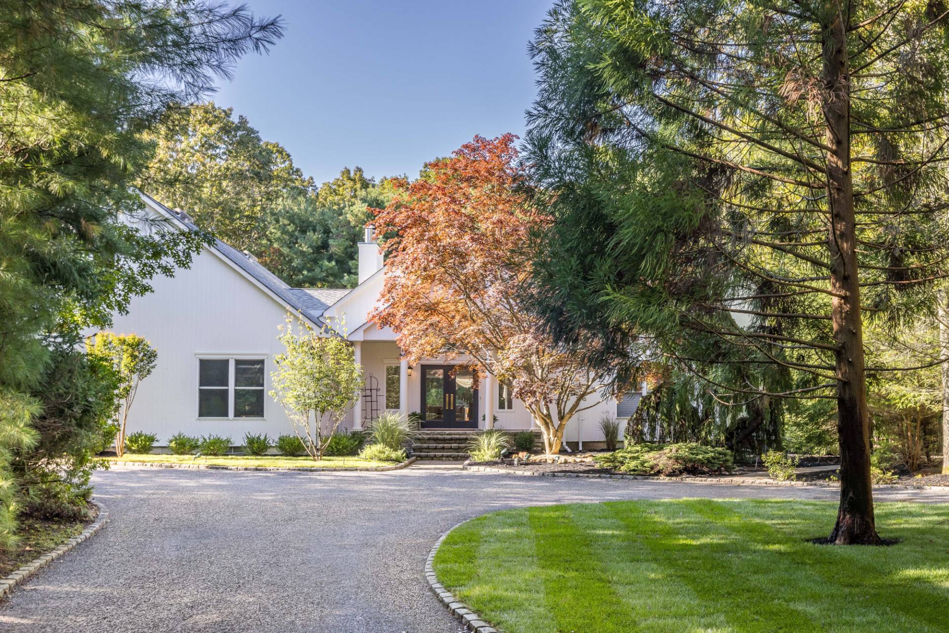 222 2 Holes Water Road East Hampton, NY 11937 - Photo 1 of 32 a front view of a house with a garden and trees