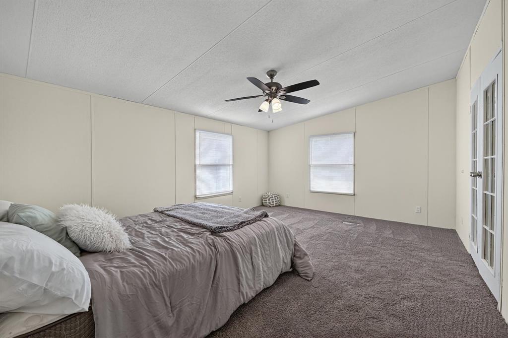 13405 Wheat Road Venus, TX 76084 - Photo 24 of 32 Spacious room featuring neutral wall paneling, gray carpet, and a ceiling fan with light fixture