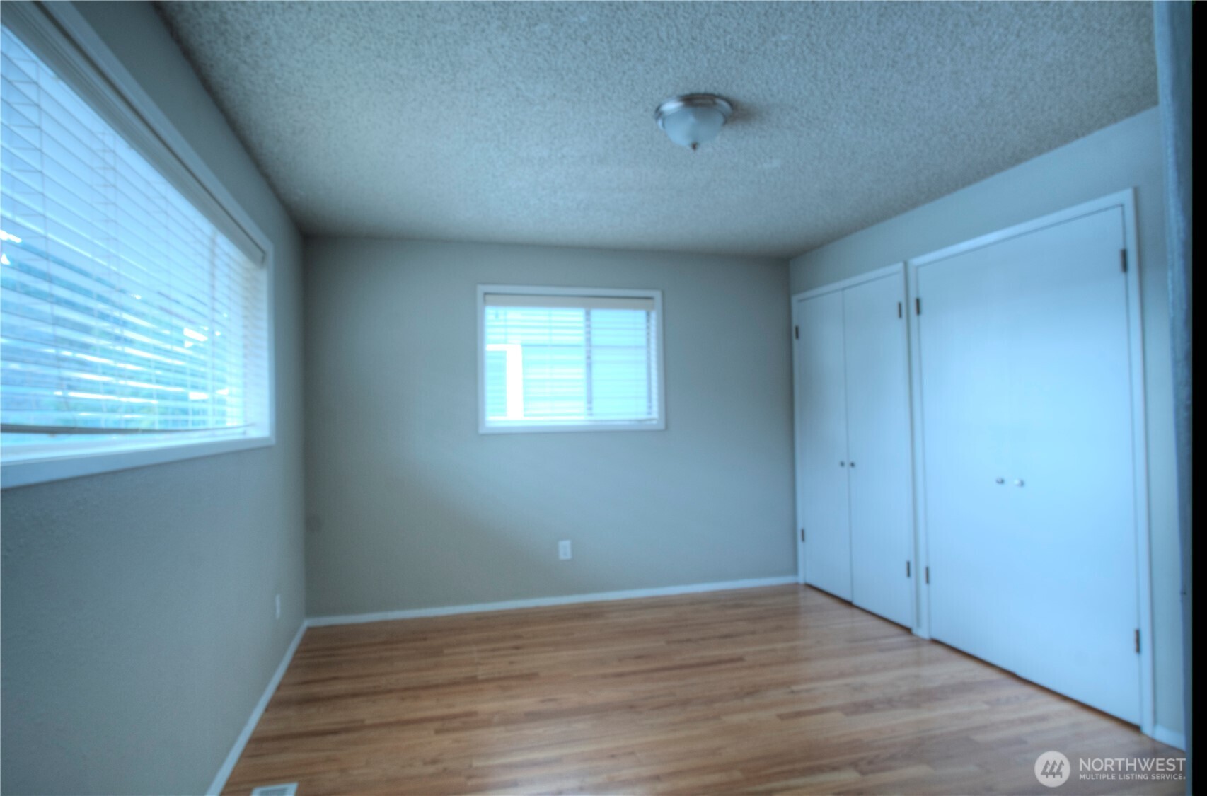 6605 South 127th Place Seattle, WA 98178 - Photo 14 of 28 a view of an empty room with wooden floor and a window