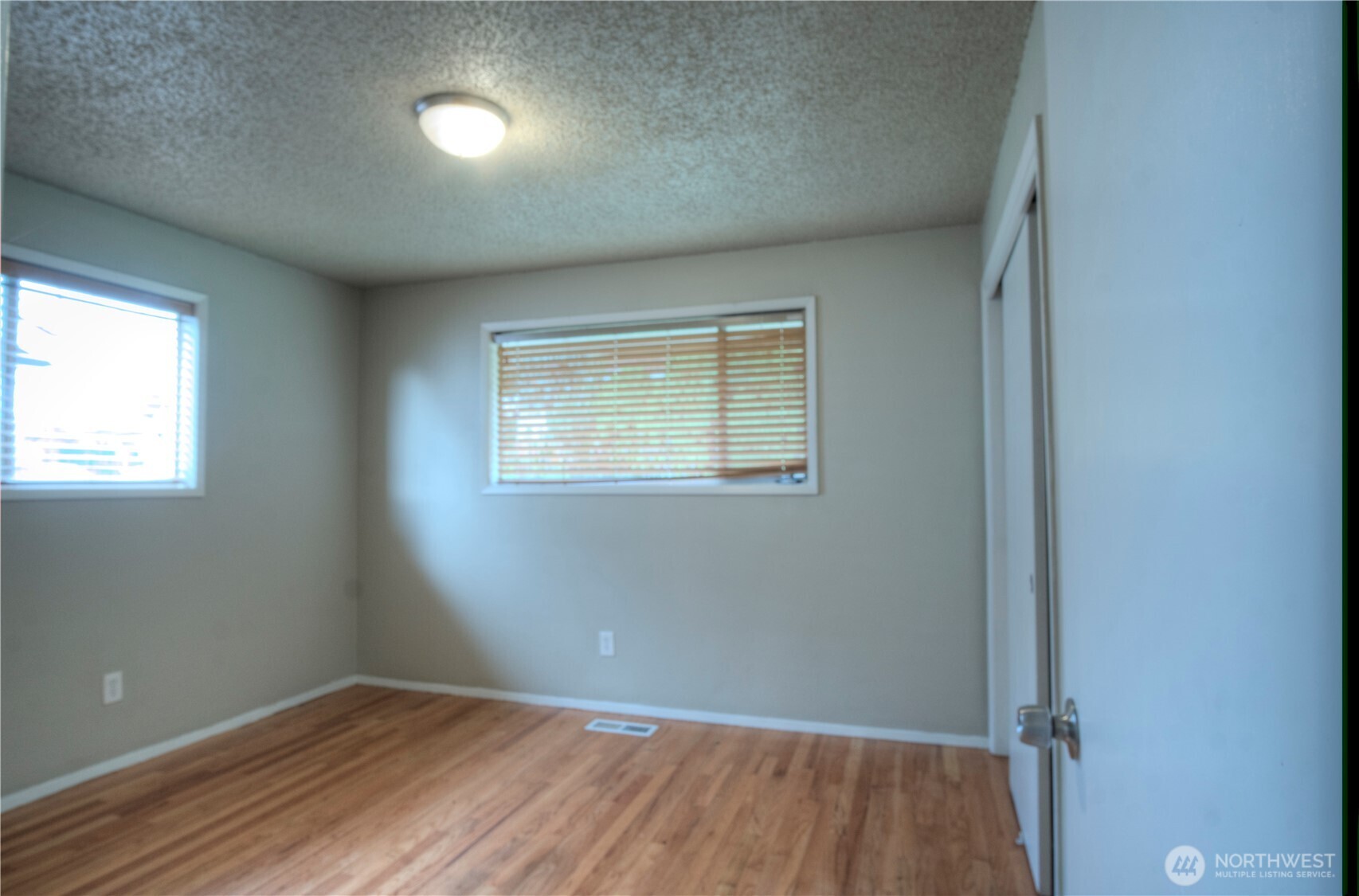 6605 South 127th Place Seattle, WA 98178 - Photo 16 of 28 an empty room with wooden floor and windows