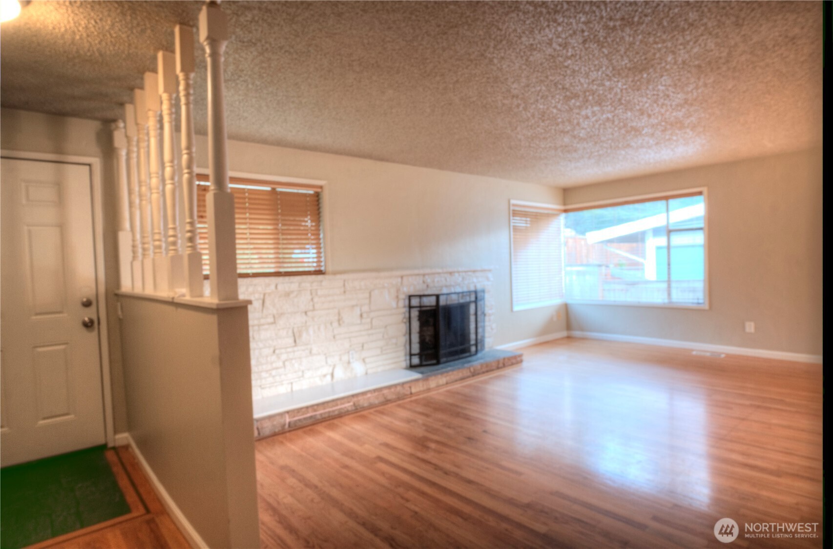 6605 South 127th Place Seattle, WA 98178 - Photo 8 of 28 an empty room with wooden floor fireplace and windows