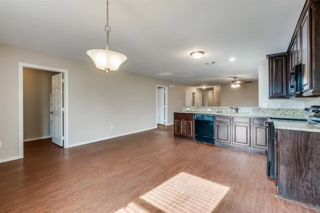 a open kitchen with kitchen island a sink dishwasher a stove and a refrigerator with wooden floor