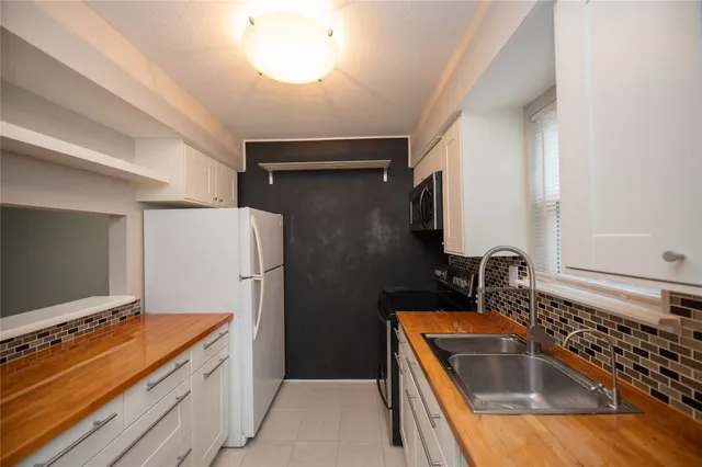 a view of kitchen with refrigerator stove and wooden floor