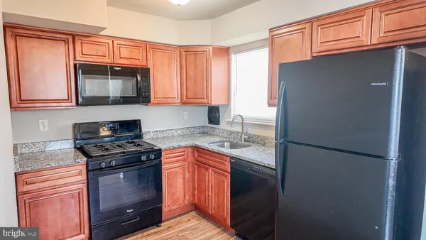 a kitchen with stainless steel appliances granite countertop a refrigerator stove and sink