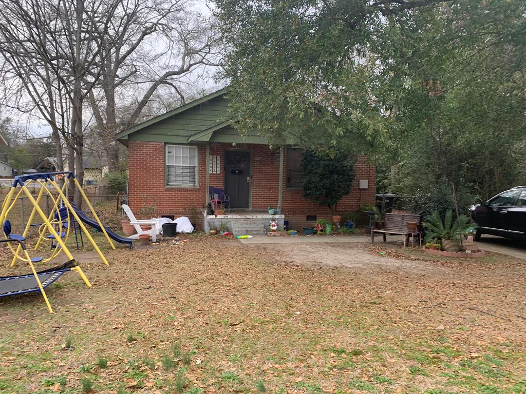a view of a house with backyard and sitting area
