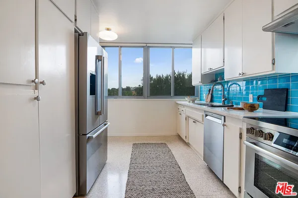 a kitchen with stainless steel appliances granite countertop a refrigerator and a stove