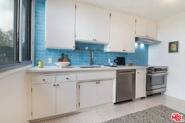 a kitchen with white cabinets and white appliances