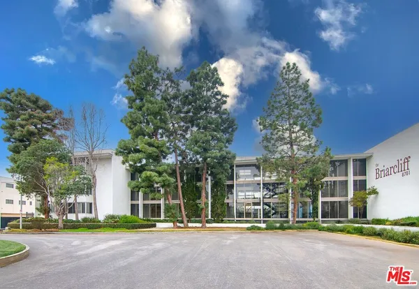 a front view of a building with trees
