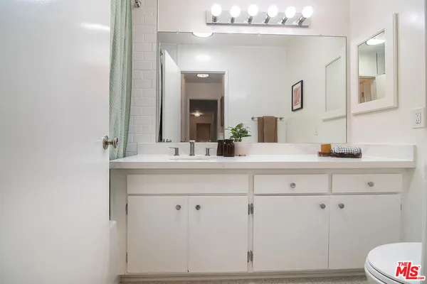 a bathroom with a sink vanity and mirror