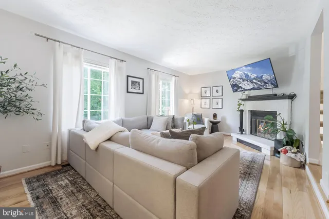 a living room with furniture a large window and a fireplace