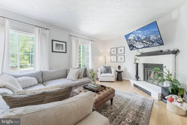 a living room with furniture large window and a fireplace