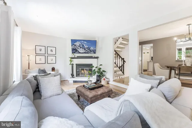 a living room with furniture a rug and a wall painting