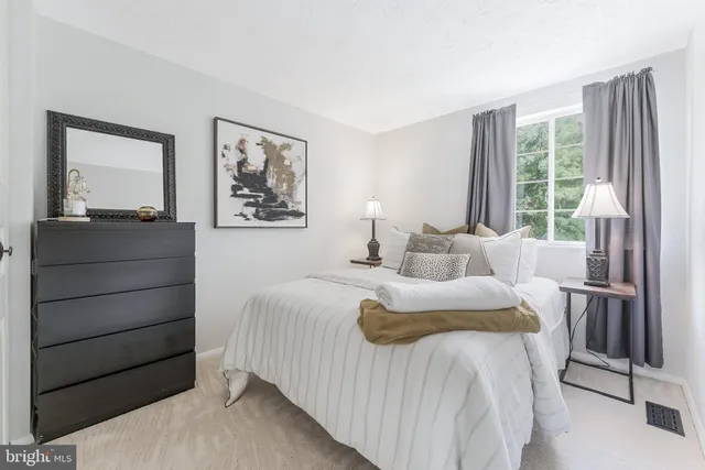 a bedroom with a bed and a large window