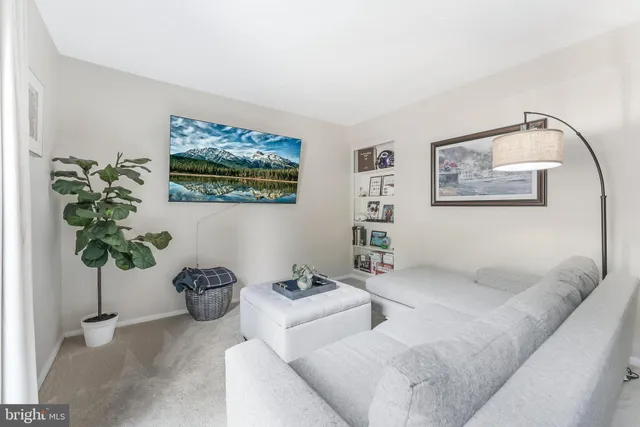 a living room with a couch a rug floor to ceiling window and a table