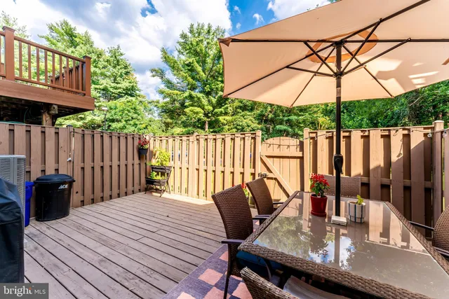 a view of a house with wooden deck and furniture