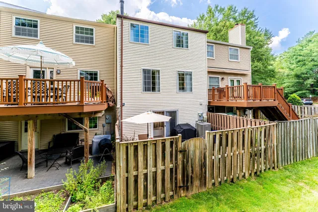 a view of a house with wooden deck and furniture