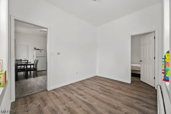 a view of a dining hall with wooden floor and a sink