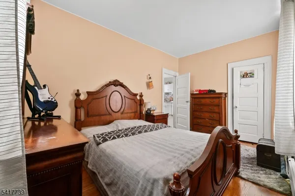 a bedroom with a bed and dresser with mirror
