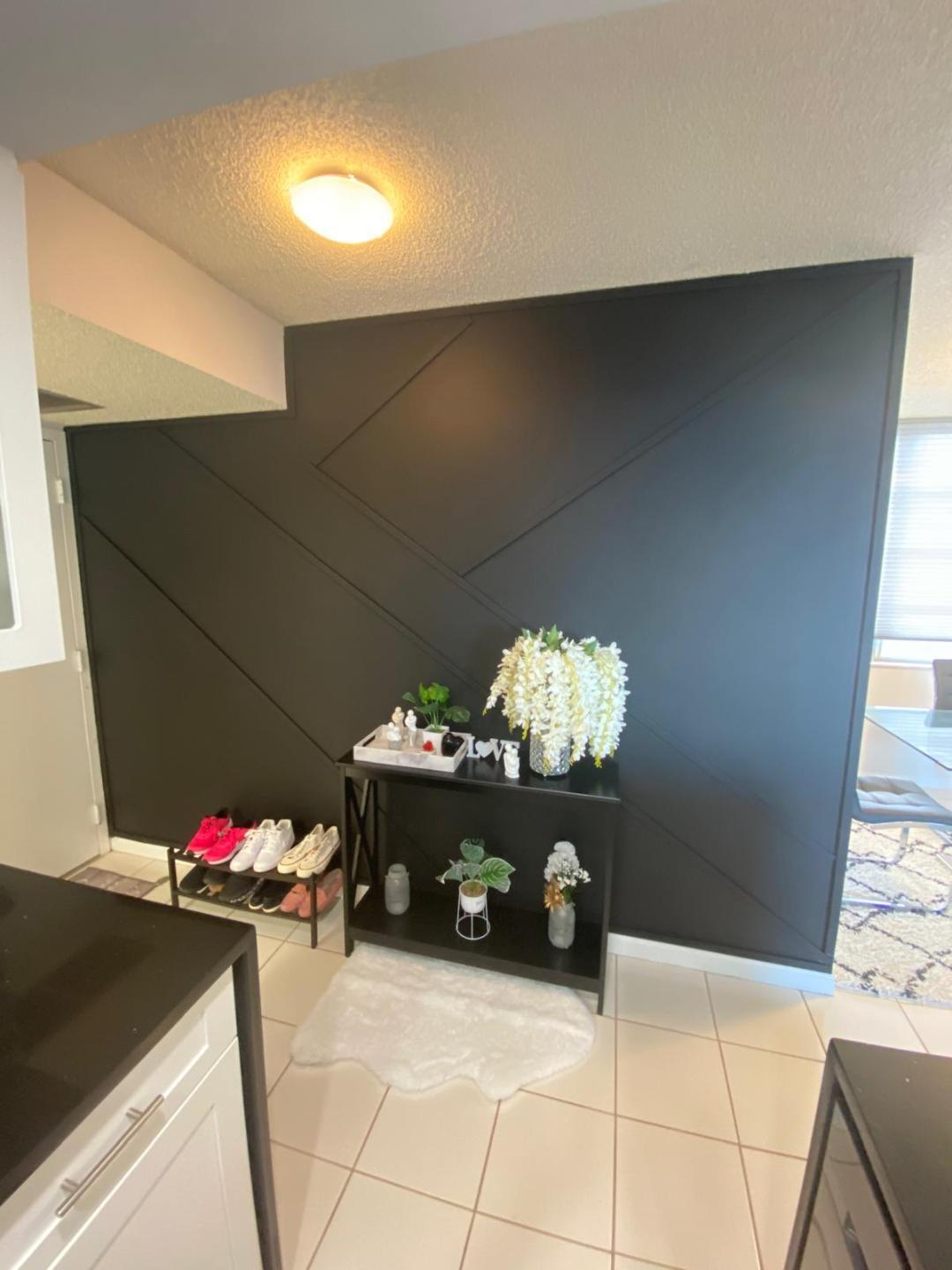 6921 Environ Boulevard, Unit 7N Lauderhill, FL 33319 - Photo 3 of 11 a hallway with a dining table and a chandelier