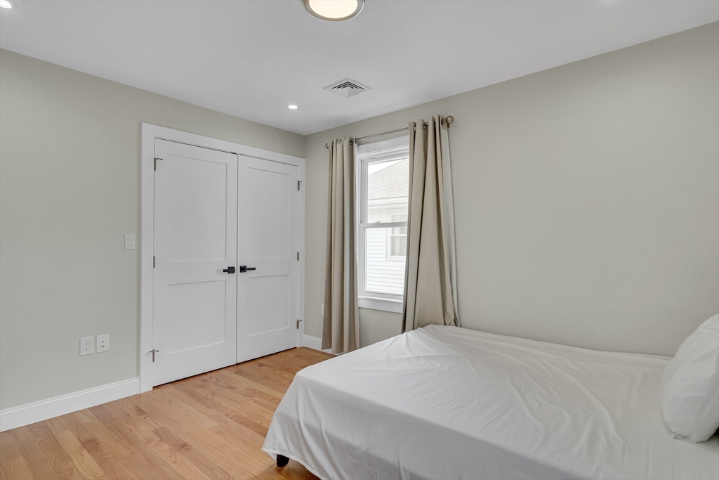 52 Holyoke Street, Unit 2 Quincy, MA 02171 - Photo 11 of 25 a bedroom with a bed and wooden floor