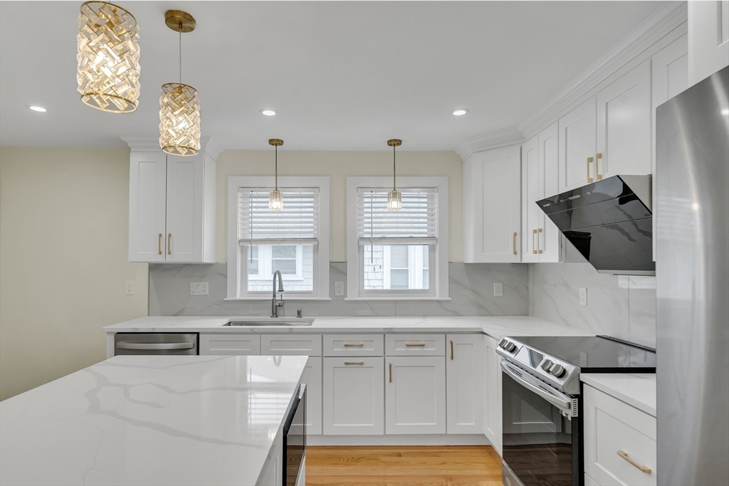 52 Holyoke Street, Unit 2 Quincy, MA 02171 - Photo 5 of 25 a kitchen with granite countertop a sink stainless steel appliances and cabinets