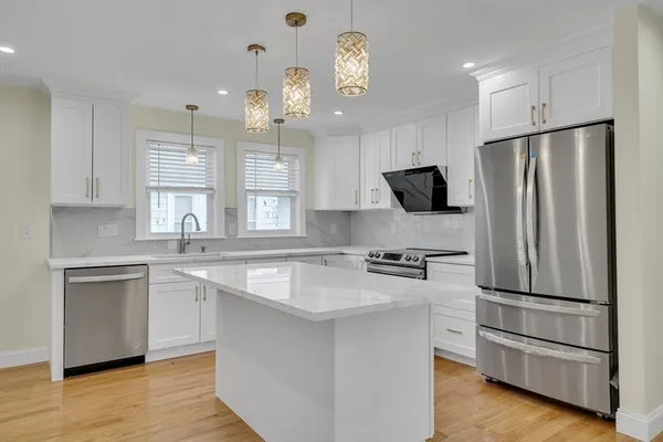 a kitchen with stainless steel appliances a refrigerator sink and microwave