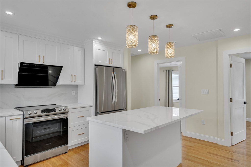 52 Holyoke Street, Unit 2 Quincy, MA 02171 - Photo 8 of 25 a kitchen with stainless steel appliances a stove microwave and a refrigerator