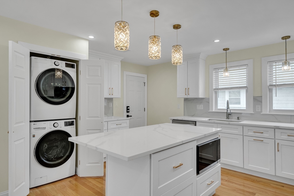 52 Holyoke Street, Unit 2 Quincy, MA 02171 - Photo 9 of 25 a kitchen with a stove top oven a sink and a clock