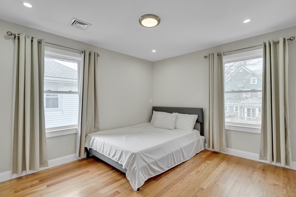 52 Holyoke Street, Unit 2 Quincy, MA 02171 - Photo 10 of 25 a bedroom with a large bed and wooden floor