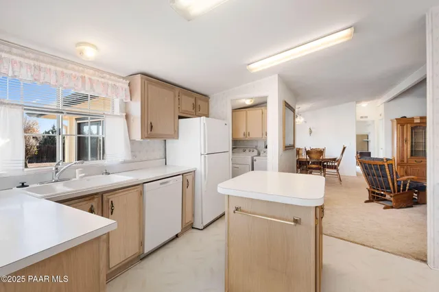 a large kitchen with kitchen island a sink stove and white cabinets