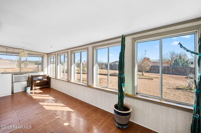 a living room with furniture and a floor to ceiling window