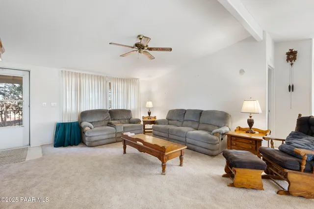 a living room with furniture and a ceiling fan