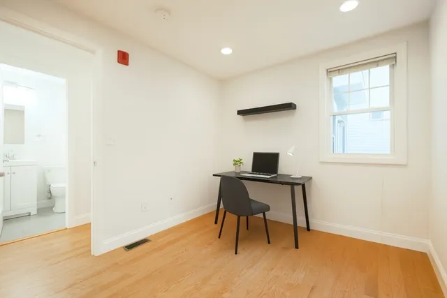 a view of empty room with wooden floor