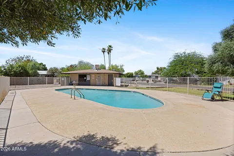 a view of a swimming pool with a lawn chairs and a small yard