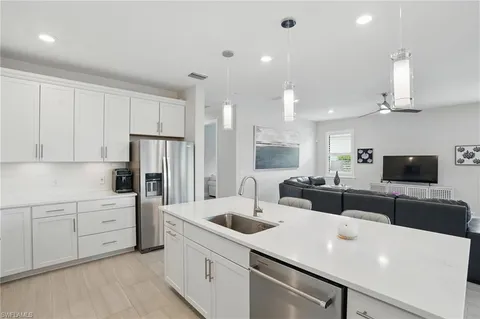 a kitchen with a sink a stove and white cabinets