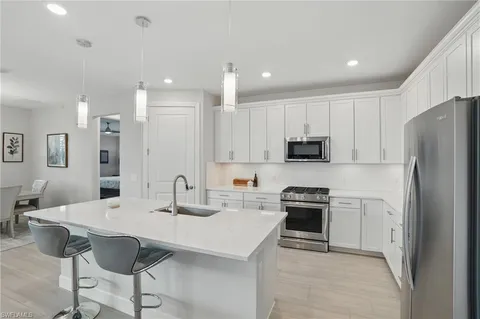 a kitchen with stainless steel appliances a stove a sink a microwave and a refrigerator