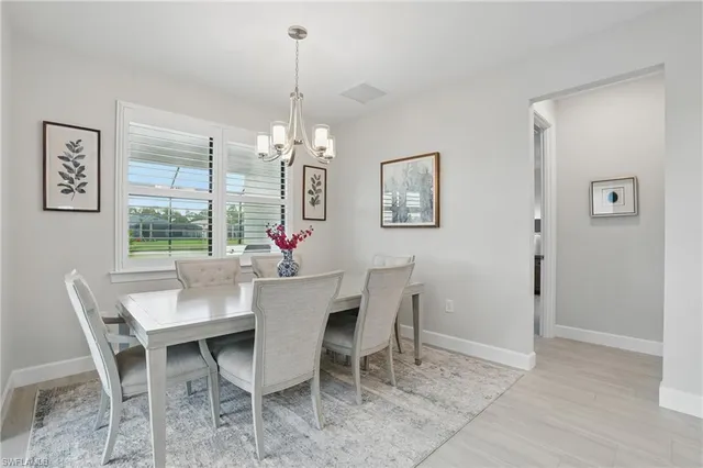 a view of a dining room with furniture a chandelier and window