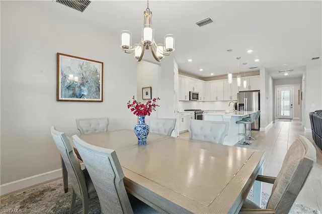 a dining room with wooden floor a chandelier a wooden table and chairs