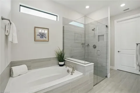 a bathroom with a tub a shower and a sink