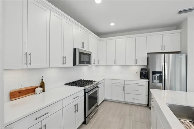 a kitchen with white cabinets and white appliances