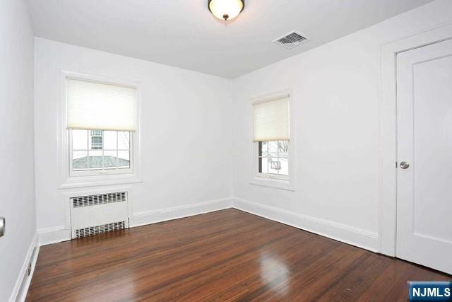 220 Raymond Street Hasbrouck Heights, NJ 07604 - Photo 19 of 36 a view of an empty room with wooden floor and a window