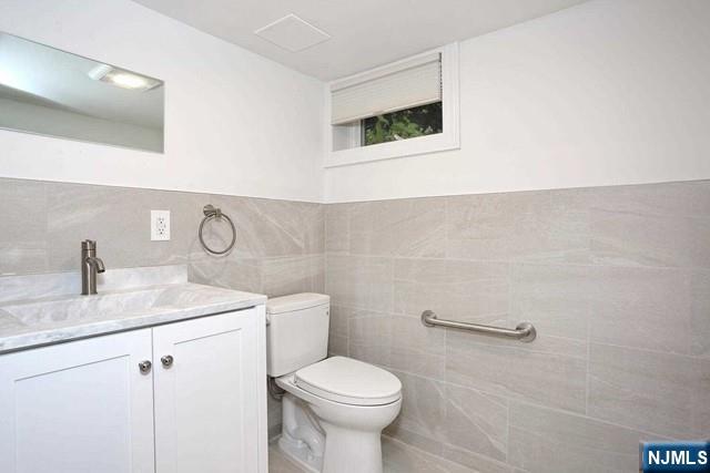 220 Raymond Street Hasbrouck Heights, NJ 07604 - Photo 31 of 36 a bathroom with a toilet sink vanity and mirror
