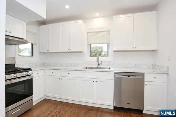 a kitchen with granite countertop white cabinets and white appliances