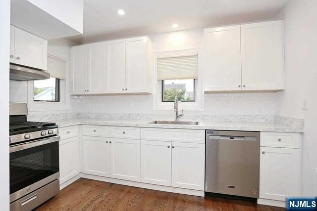 220 Raymond Street Hasbrouck Heights, NJ 07604 - Photo 5 of 36 a kitchen with granite countertop white cabinets and white appliances
