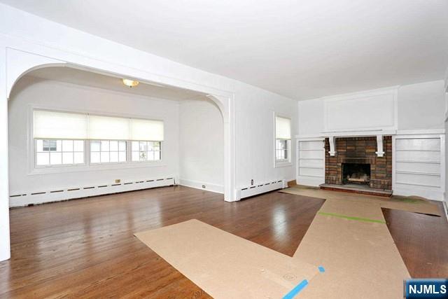 220 Raymond Street Hasbrouck Heights, NJ 07604 - Photo 9 of 36 an empty room with windows and fireplace