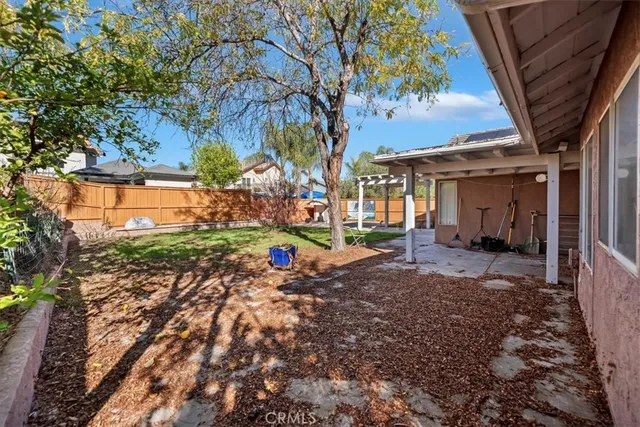 a view of a patio with table and chairs potted plants with wooden floor and fence