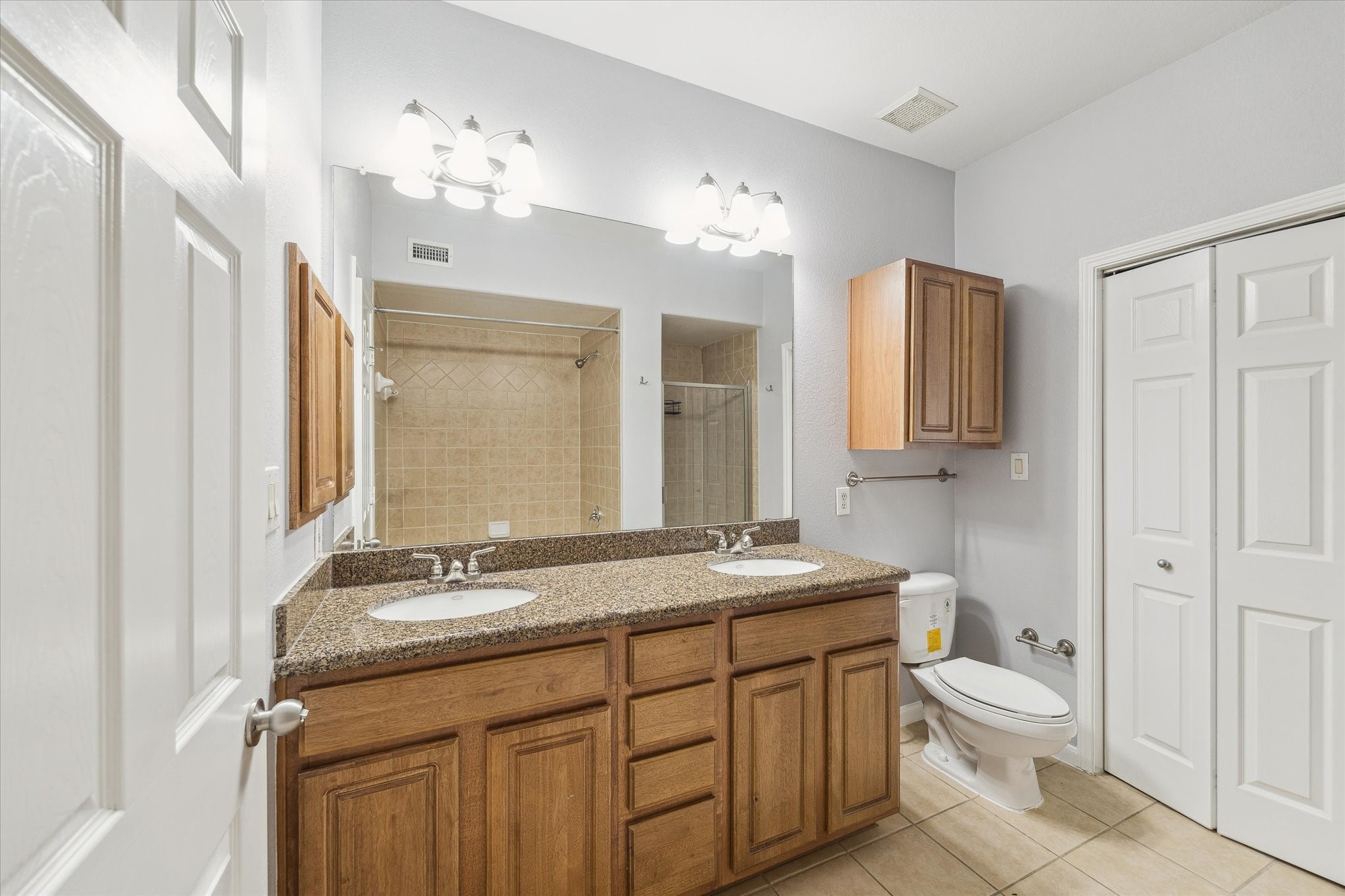 9200 Westheimer Road, Unit 907 Houston, TX 77063 - Photo 9 of 27 a bathroom with a granite countertop sink toilet a large mirror a vanity and shower