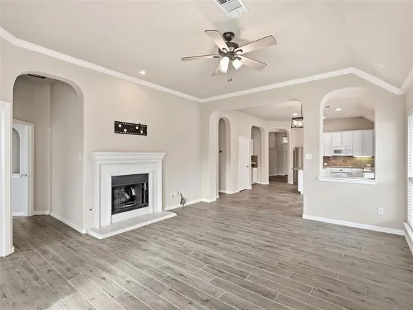 an empty room with wooden floor and fireplace