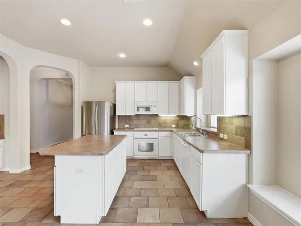 a view of kitchen with white cabinets